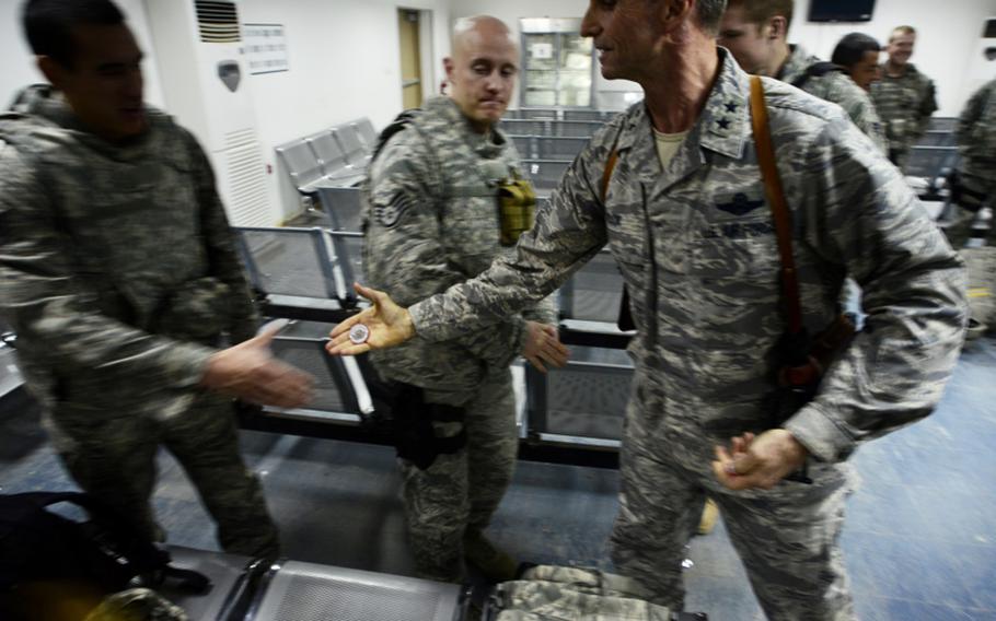 Maj. Gen. Anthony J. Rock, who directed the Iraqi Training and Advisory Mission, hands coins to the last U.S. airmen to leave Iraq at Ali Air Base, Tallil, Iraq.