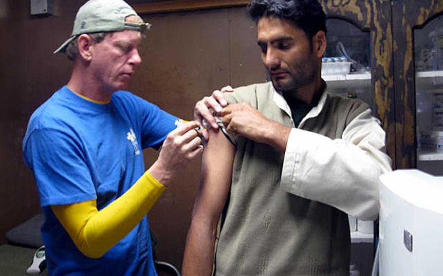 Civilian medic Cory Kraus gives Abdul Aman Hijartullah one of several rabies shots after the Afghan, who works for a subcontractor hauling trash from FOB Apache to the dump, was bitten by a dog and feared he'd get the deadly disease.
