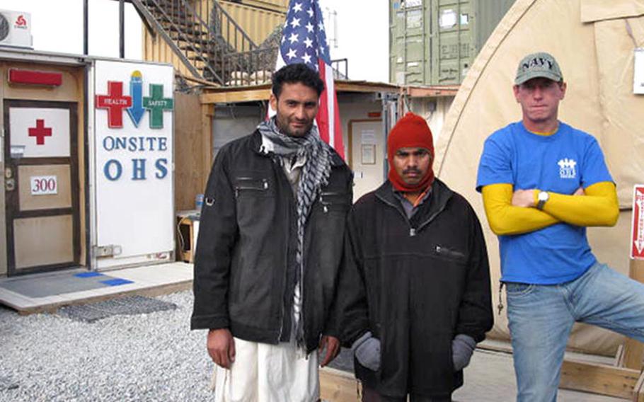 Key in helping Abdul Aman Hijartullah get life-saving treatment was his on-base escort and friend, Raveendran Kizhu Veetil, center. Veetil encouraged his friend to bring his dog bite to the attention of U.S. personnel and translated for him. At right is medic Cory Kraus.