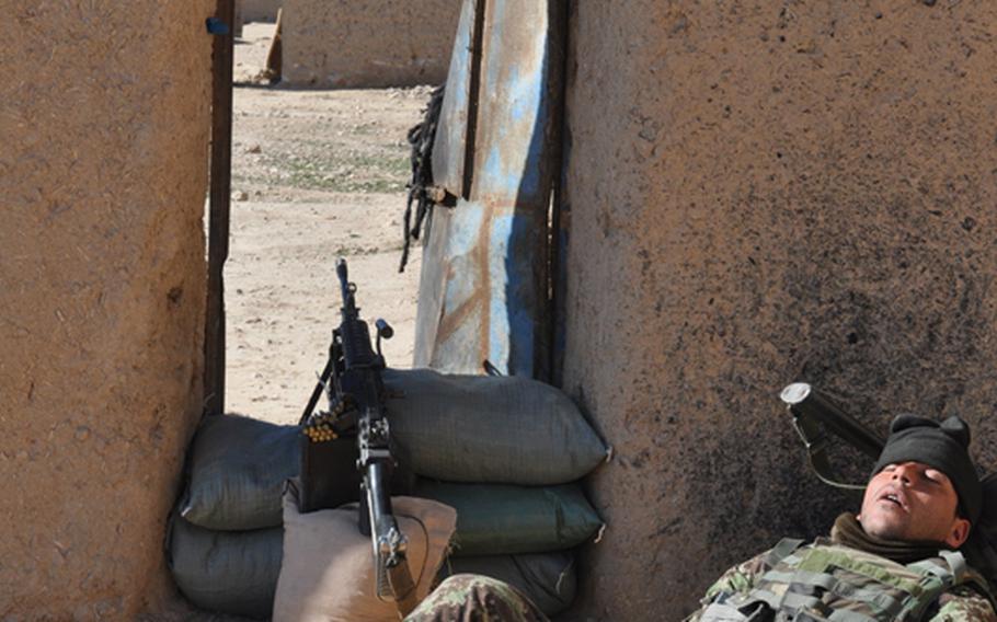 An Afghan soldier guarding the door to a compound occupied by Afghan and U.S. troops during a recent mission to Ghorak district, Kandahar province.