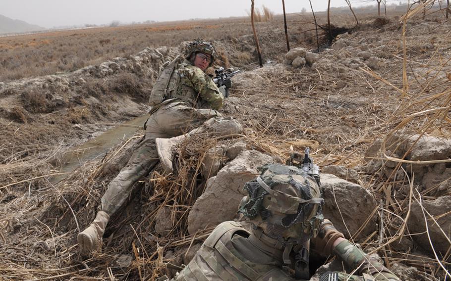 Spc. James Whaley, 25, right, and Pfc. Preston Rotella, 19, keep eyes on a nearby firefight in the Pashmul area of Kandahar province.