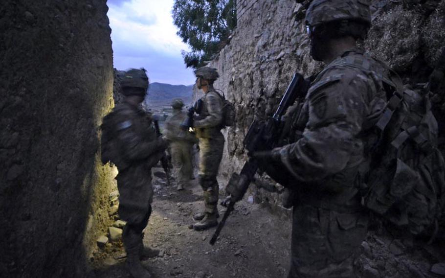 Soldiers with the 1st Battalion, 501st Infantry Regiment stand in the alley where Staff Sgt. Damian Remijio and Pfc. Zachary Fitch were wounded in an April 12, 2012, firefight in a village in Khost province.