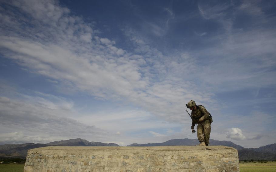 Staff Sgt. Michael Johnson with the 1st Battalion, 501st Infantry Regiment searches a stone structure in the village of Maktab near the Pakistani border of eastern Afghanistan&#39;s Khost province.