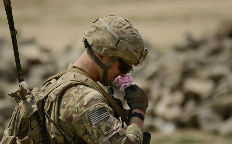 Pfc. Steve Biter with the 1st Battalion, 501st Infantry Regiment smells a rose while on patrol in the village of Danda Faqiran near the Pakistani border of eastern Afghanistan's Khost province.