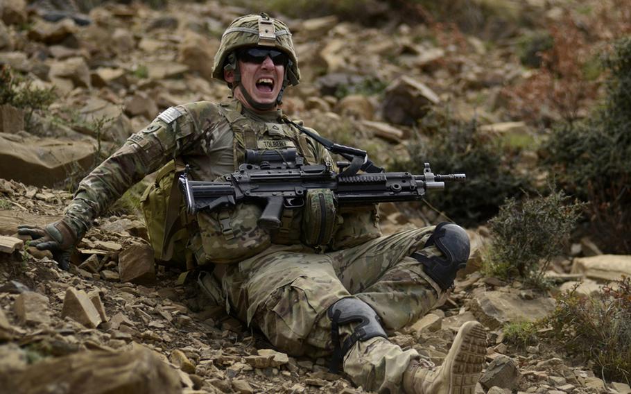 Pfc. Nicholas Tolbert grimaces with pain and laughter after losing his footing while descending a foothill near the Pakistani border in eastern Afghanistan&#39;s Khost province.