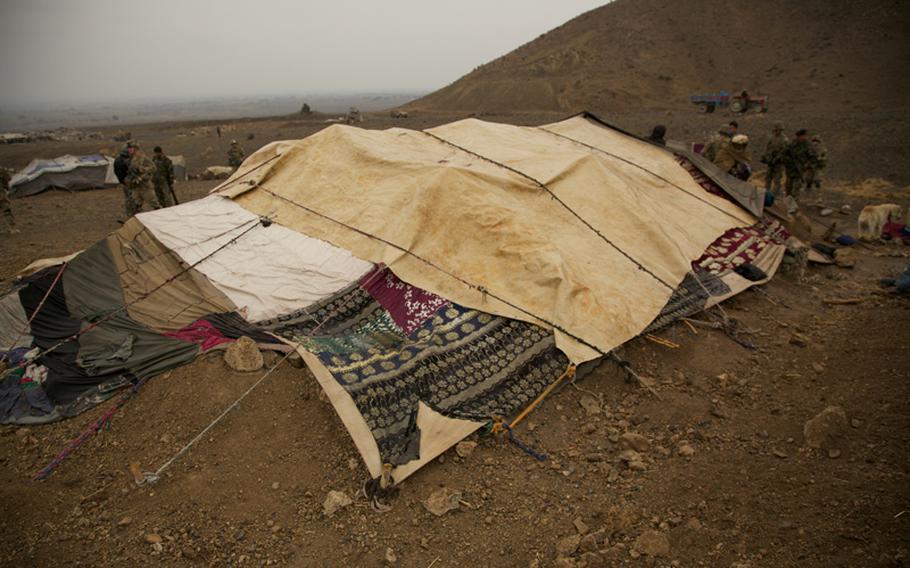 On the far side of a tent used by nomadic herdsmen, Spc. Victor Cornejo, 34, a medic from Palm Springs, Calif., examines the scalp of an Afghan woman who complained of painful lumps on her head. Afghan women are seldom seen by Western men, but Afghans make exceptions for U.S. Army medics, whom they consider doctors.