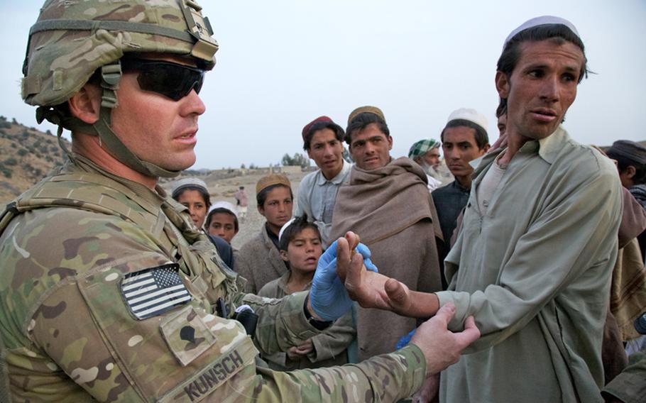 An Afghan man listens as Spc. Joe Kunsch, a 34-year old medic from Prescott, Ariz., explains he can't do anything for his finger. The man broke the finger a month earlier and didn't seek treatment. Instead, he doused it with henna, a natural dye commonly used to treat wounds in the part of Afghanistan's Khost province. Kunsch says the dye probably doesn't hurt, but certainly doesn't help.