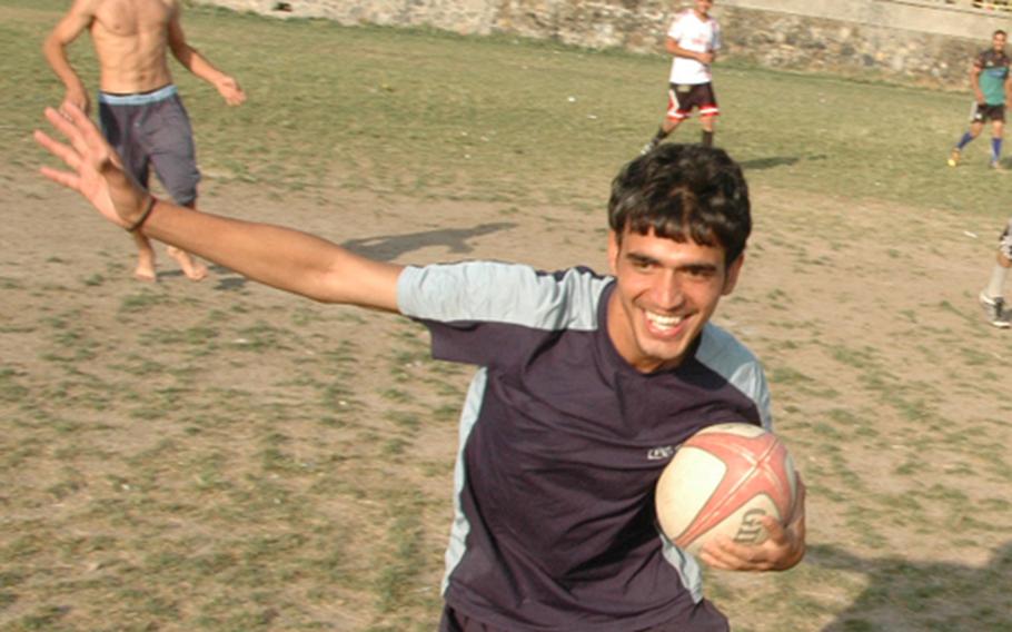 An Afghan rugby player side-steps in an effort to beat an opponent during practice at Kabul&#39;s Chaman-i-Huzuri park on Sunday.