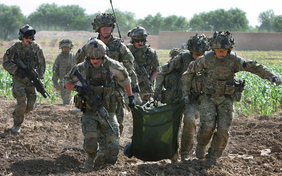 Air Force Pararescueman and Staff Sgt. Rich Alexander, left, carries a wounded Afghan soldier with British soldiers while Capt. Brock Roden, far left, and Master Sgt. Brandon Stuemke, center, cover them during a mission in Helmand province on June 23. Alexander, Roden and Stuemke are with the 46th Expeditionary Rescue Squadron.