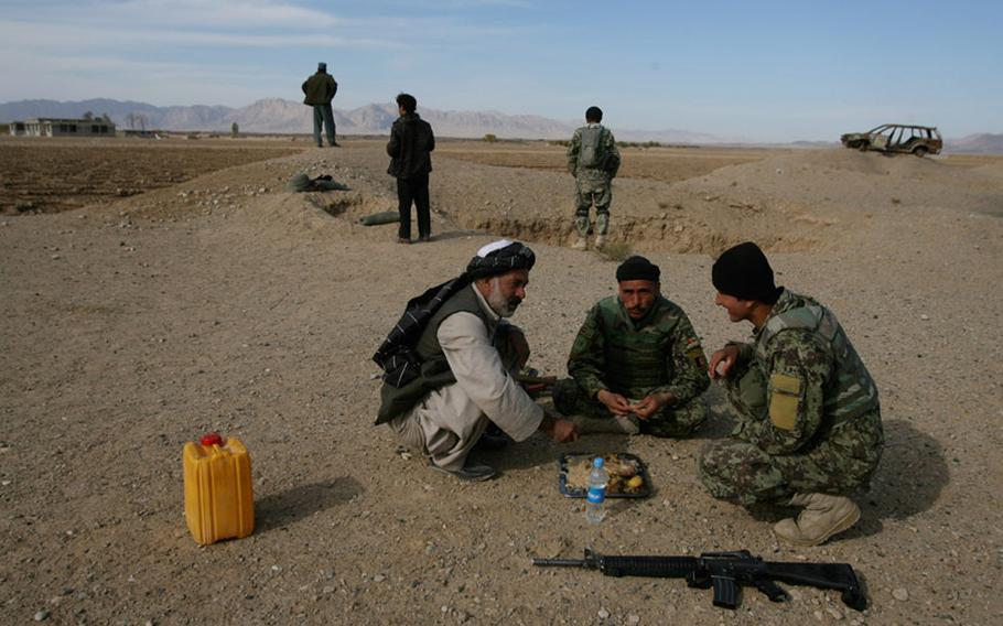 Maiwand District Governor Saleh Mohammed speaks Nov. 26 to Afghan National Army soldiers at a checkpoint along the "Road of Martyrs" in northwestern Kandahar province, Afghanistan.