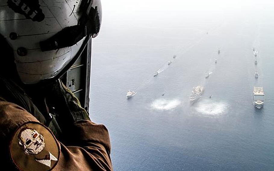 Petty Officer 3rd Class Travis Calvan, an air crewman, looks on May 19, 2013, as ships from various countries participating in the international mine countermeasures exercise in the Persian Gulf, which started the week of May 13, 2013.

Hendrick Simoes/Stars and Stripes