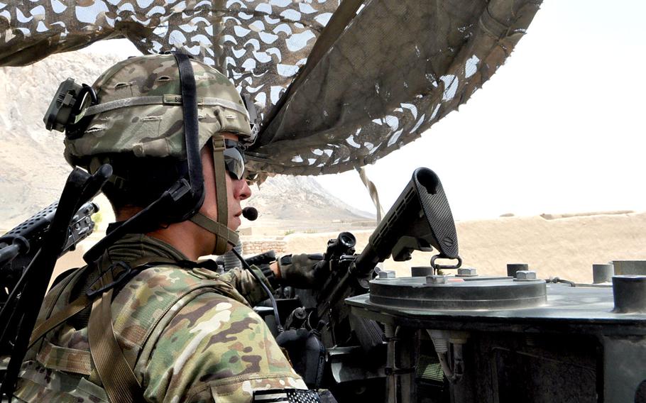 Staff Sgt. Brandon Bamford mans the gun on a Stryker vehicle while riding the "Panjwai 500," the main East-West road in the district of Kandahar province. The 2nd Cavalry Regiment is trying to build an understanding of the people who live in Panjwai district. Bamford said children are still liable to hurl rocks at passing American vehicles.