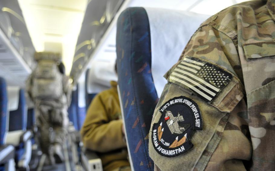 Troops settle into their seats aboard a civil airliner for a flight departing from Manas International Airport in Kyrgyzstan, on a trip bound for Europe and eventually, the United States.