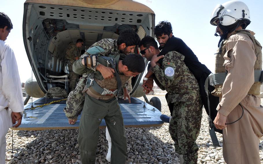 Afghan National Army soldiers and Afghan Air Force airmen help carry wounded soldiers into the back of an Mi-17 helicopter at Camp Leatherneck in southwest Afghanistan in June 2013. Afghan security forces have faced rising casualties as international troops depart and fighting continues.