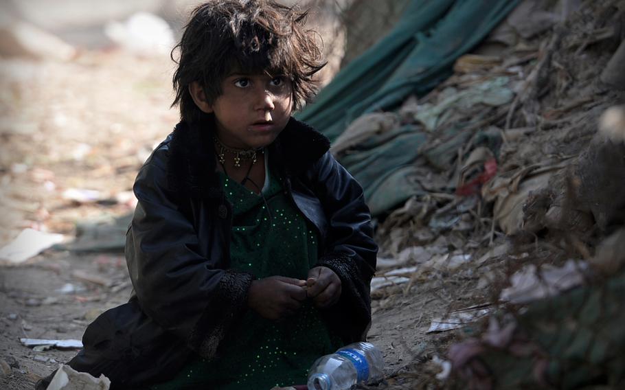 An Afghan girl plays in the dirt at a camp in Kabul for refugees who have returned from Pakistan. Women and children in Afghanistan are especially vulnerable when displaced by violence and economic hardship.