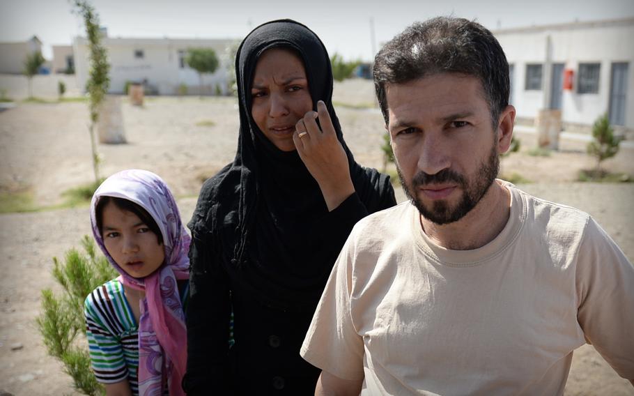 Nargis Amiri, center, cries as she recalls harassment by Iranian officials who deported her, her husband, and daughter back to Afghanistan. The small family, which had been hoping for a chance to find better work in Iran, had only a few days to spend at this United Nations camp in Herat province in July 2014.
