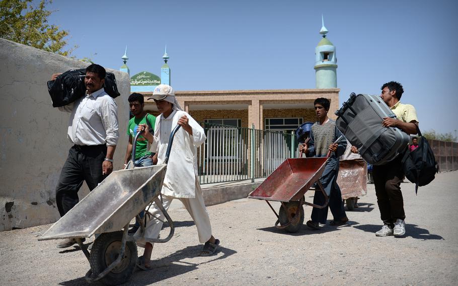 Afghan refugees cross the border back into Afghanistan after being deported from Iran in July 2014. Aid officials say economic hardship is driving many Afghans to seek better opportunities in other countries.