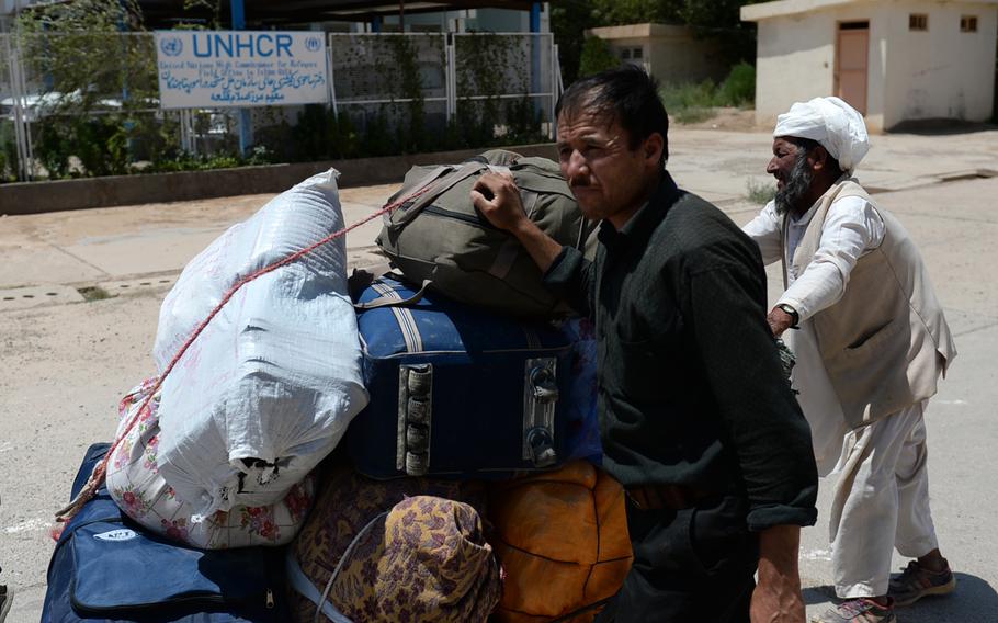 Afghan refugees cross the border back into Afghanistan in July 2014 after being deported from Iran. Aid officials say economic hardship is driving many Afghans to seek better opportunities in other countries.