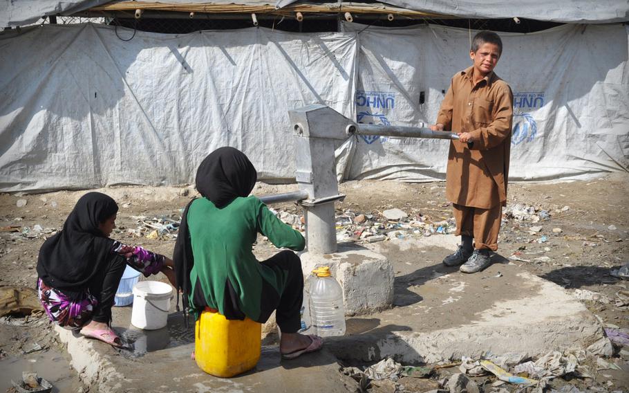 Afghan children pump water at a camp for internally displaced people in Kabul, Afghanistan on October 2013. Some 800,000 Afghans remain displaced inside their own country despite years of international intervention.