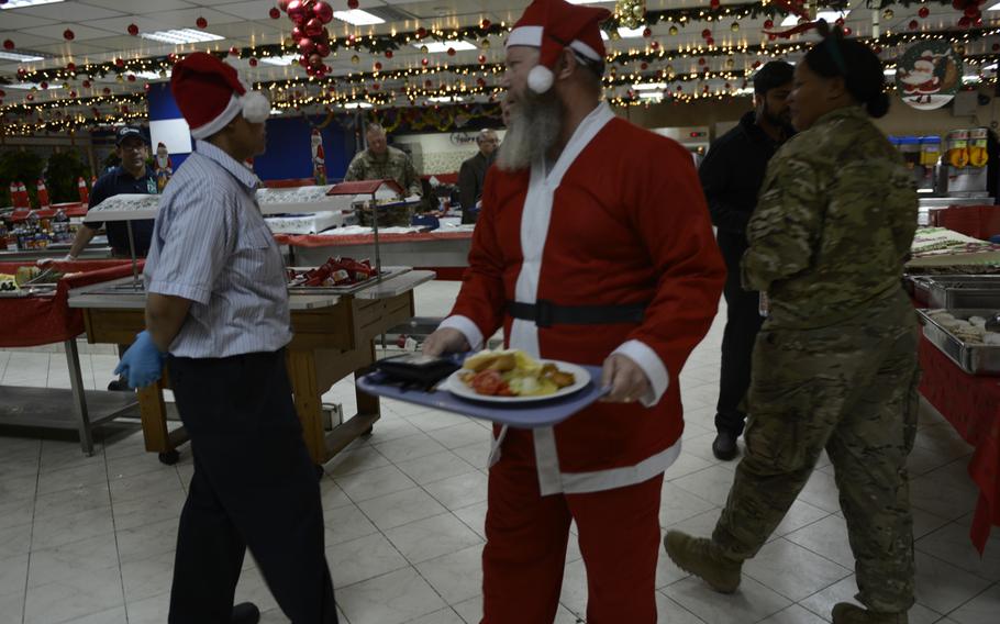 Santa walks through a dining hall at the headquarters of the international military coalition in Afghanistan on Dec. 25, 2014.