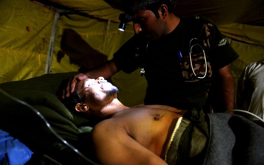 An Afghan army medic examines a local policeman who was critically injured last month when he was shot during a joint operation in Nangarhar province. Limited resources meant the army could not evacuate him to a better hospital.