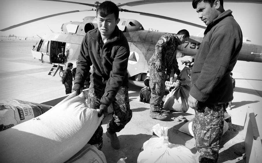 Afghan National Army soldiers unload food and other supplies from a truck onto a waiting Mi-17 helicopter at a desert base in southern Afghanistan. The over-stretched Afghan Air Force has only a handful of aircraft to not only supply remote outposts, but evacuate wounded and transport troops.