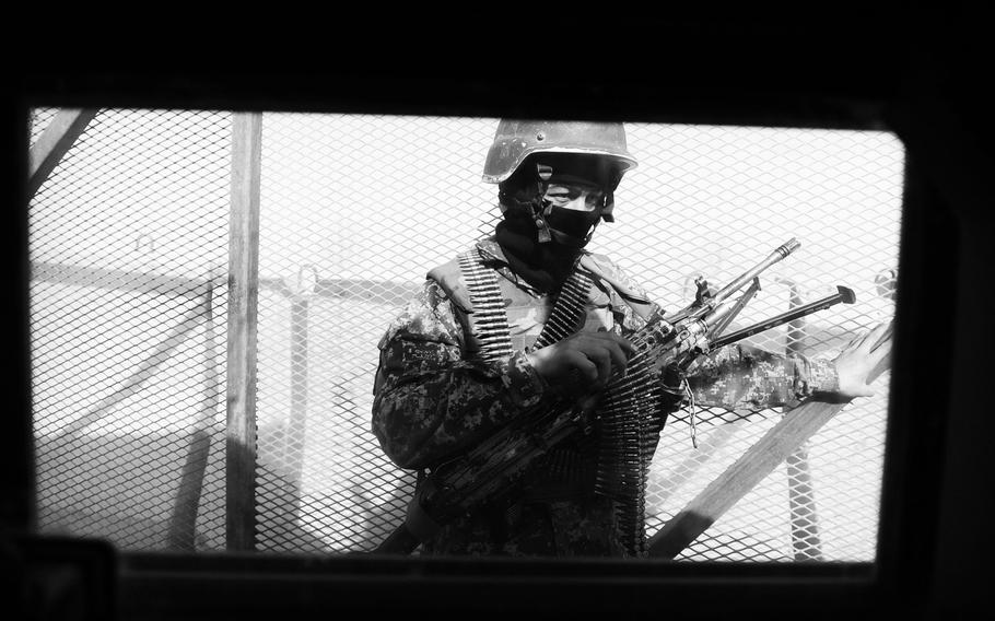 An Afghan National Army soldier guards the gate at the former American forward operating base in Masum Ghar. Coalition forces abandoned hundreds of bases around Afghanistan, many of which are now used by the ANA.