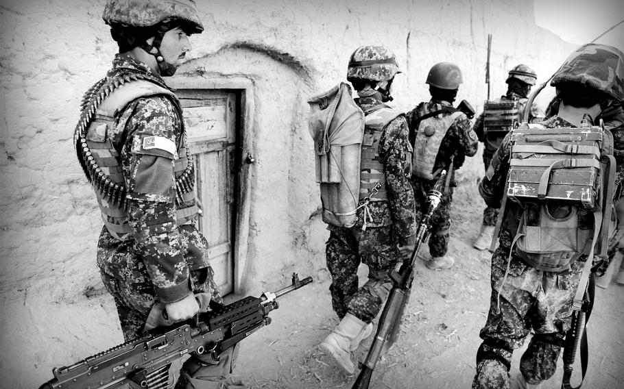 Afghan soldiers patrol a village in Panjwai district in southern Afghanistan on Jan. 5, 2015. Officials say a push to maintain a regular presence by security forces has led to a decrease in Taliban influence in the area.