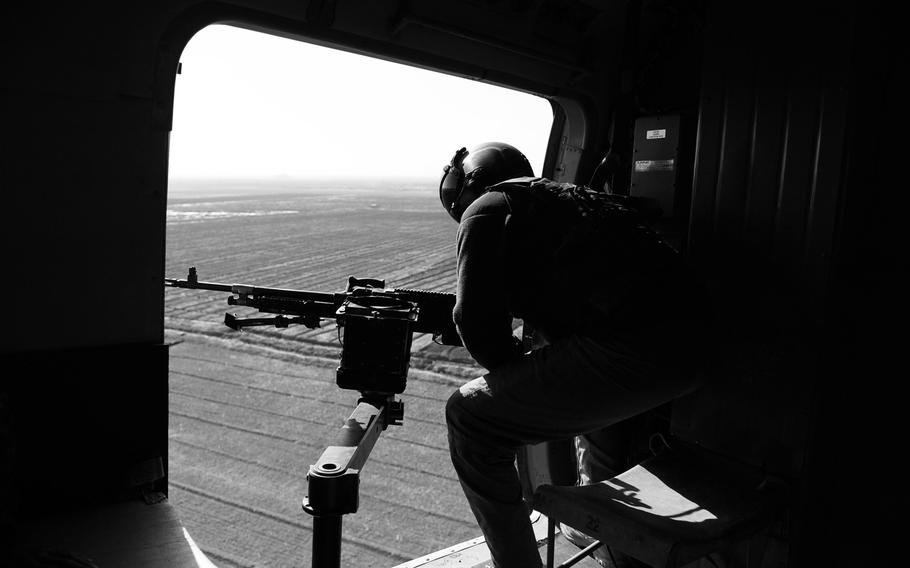 An Afghan Air Force crew chief scans for threats from the door of an Mi-17 helicopter over Kandahar province in southern Afghanistan. With the departure of most foriegn troops, such aircraft provide vital support for security forces scattered around the country.