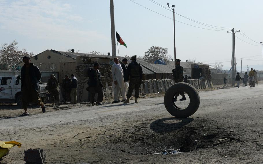 Troops from the Afghan Interior Ministry oversee the cleanup after a suicide bombing outside the Green Village compound in eastern Kabul, Thursday, Nov. 20, 2014.