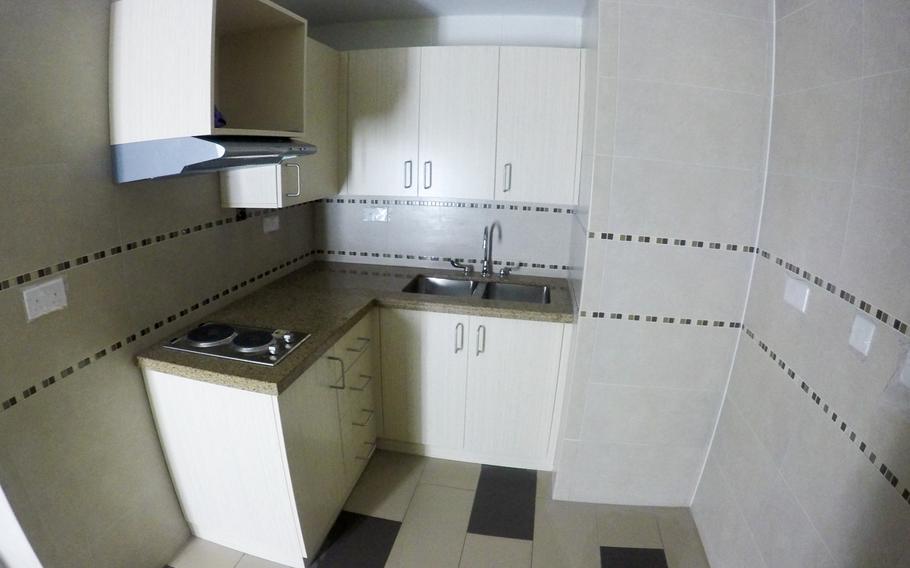A wide angle-view of the kitchen area of a roughly 460-square-foot suite inside a barracks building under construction at Naval Support Activity Bahrain. The kitchen will include a ministove and two lockable refrigerators, one for each person living in the unit.