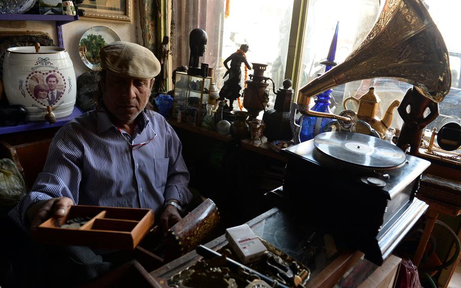 Aka Abu Haider Abass sifts through old colonial British coins at his antiques shop in old town Baghdad. It was under a British mandate established after World War I that Iraq's controversial modern borders were drawn.