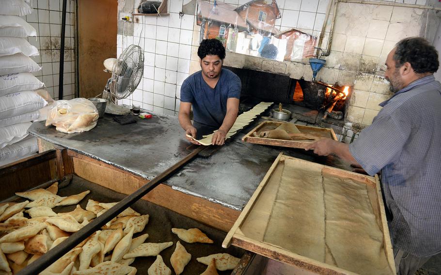 Bakers prepare traditional diamond-shaped flat bread at a bakery in Baghdad.