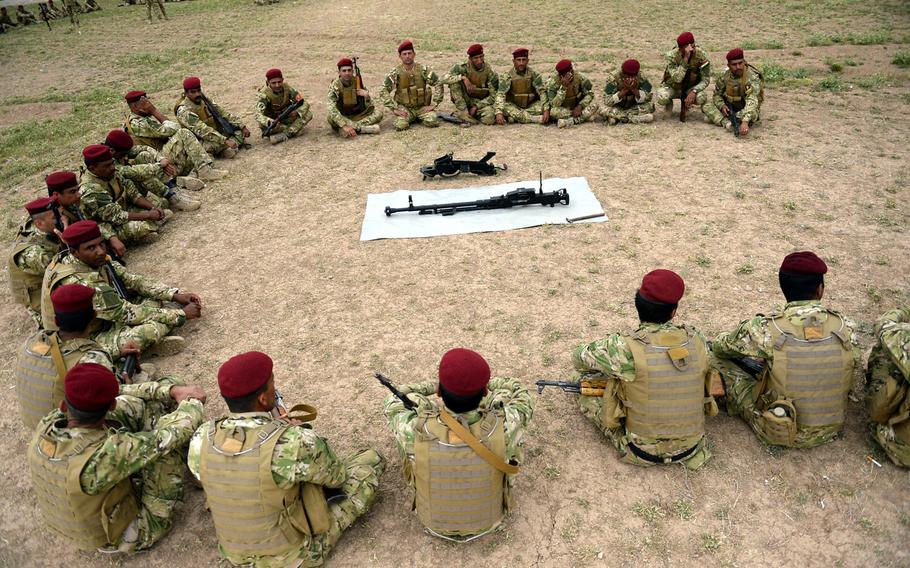 Volunteers in the fight against the Islamic State group listen to an instructor at a training camp in northern Iraq. The camp's commander says more than 5,000 fighters have been trained so far.