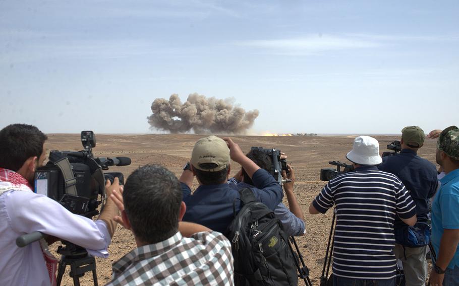 Press members watch the impacts from a B-52 bombing at the Wadi Shadiya training range in Jordan on May 18, 2015, as part of an exhibition of American and Jordanian military firepower held before officials from both countries. The event is the culminating act of the exercise Eager Lion, which is held annually in Jordan to signal U.S. support for the key Middle East ally.