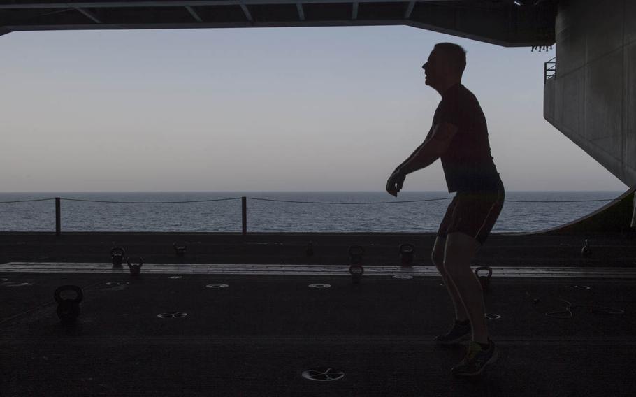 A sailor participates in a Crossfit-style fitness program in the hangar bay of the aircraft carrier USS Theodore Roosevelt Aug. 13, 2015.  The Roosevelt offers a variety of fitness programs to help sailors stay physically fit during deployment.