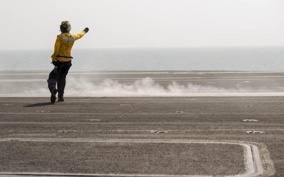 A member of the aircraft carrier USS Theodore Roosevelt's flight deck crew walks out toward the catapult after a jet launch Aug 13, 2015.