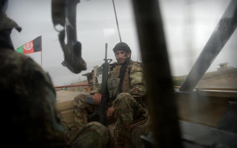 An Afghan soldier braves a summer rain storm in the back of a Ford pickup truck on a mission in Nangarhar province in August 2015. Afghan security forces face a rough life in the field on top of daily danger from insurgent bombs and ambushes.