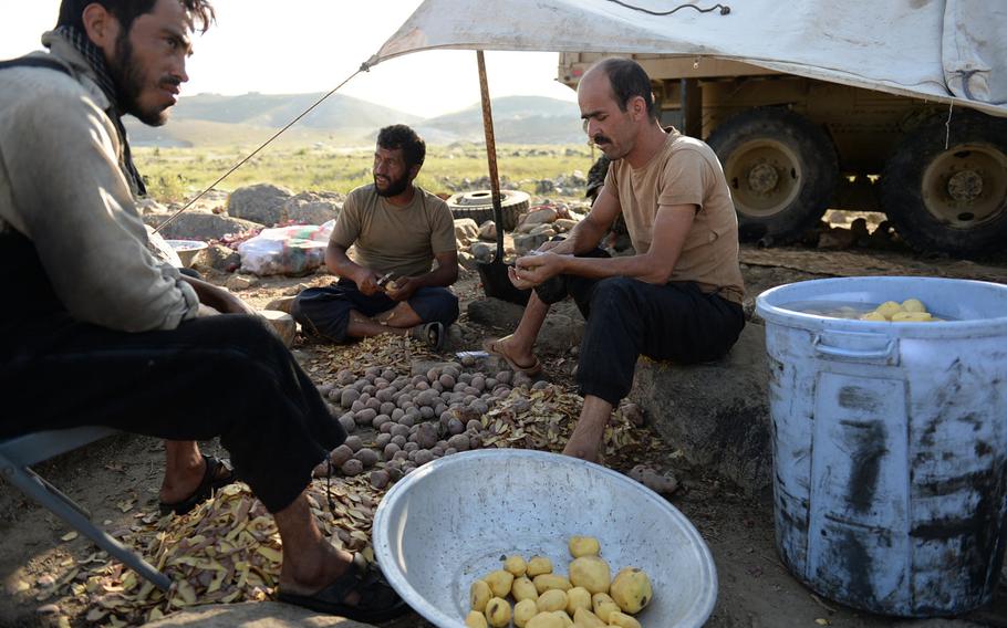 Afghan National Army soldiers peel potatoes at a forward field camp during an operation in Nangarhar province in August 2015. Some men join the army as a way to make money but find the danger and hard lifestyle difficult.