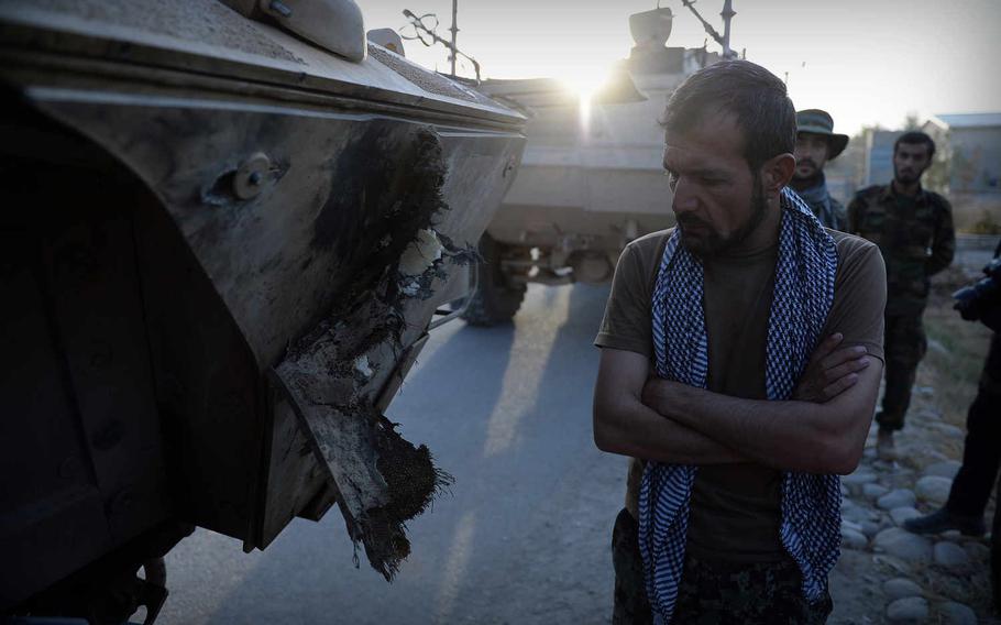 An Afghan army commander examines damage to his armored fighting vehicle caused by a Taliban rocket during battles in Kunduz city. The Taliban's lightning occupation of the city was its greatest victory since 2001.