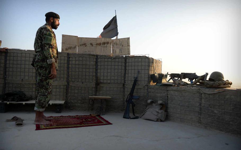 An Afghan army soldier faces the setting sun as he prays at a checkpoint near the Kunduz airport. When Taliban forces captured the city in late September 2015, most government troops retreated to the airport and a nearby military base.