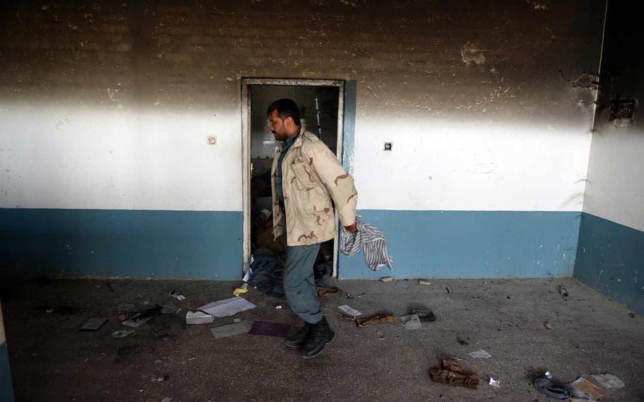 A policeman walks through the burned ruins of a police station in Kunduz, Afghanistan. The station was destroyed and as many as eight officers killed when the Taliban captured the city in September 2015.