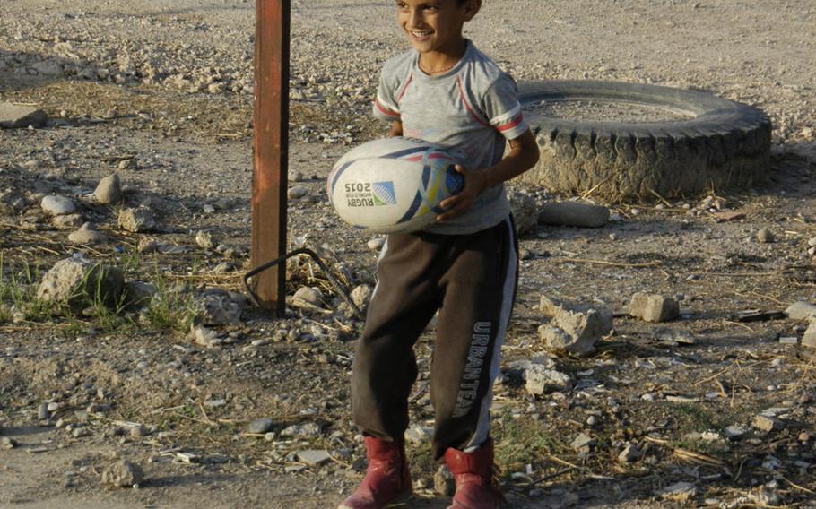 A Yazidi boy smiles as he prepares to show off his rugby skills at a camp for displaced people in Irbil, Iraq, Oct. 25, 2015.