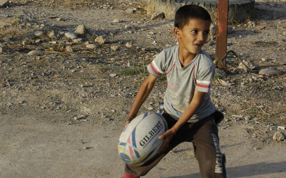 A Yazidi boy prepares to throw a rugby ball at a camp for displaced people in Irbil, Iraq, Oct. 25, 2015.