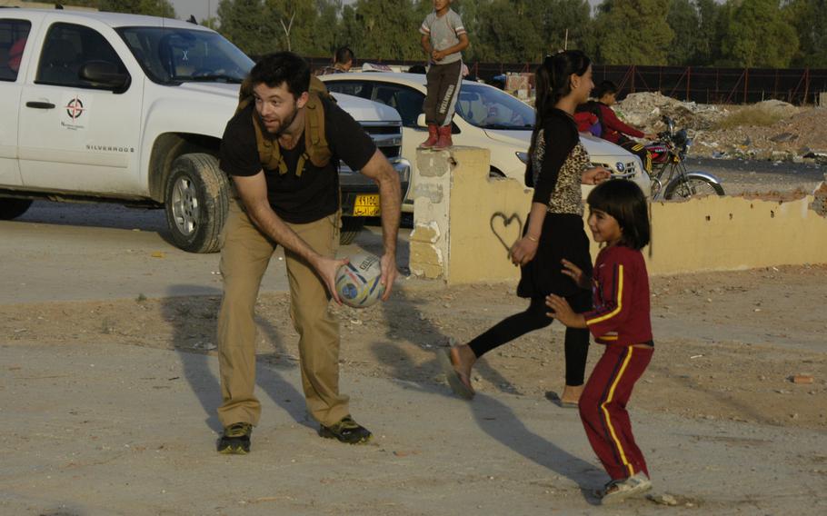 New Zealander Campbell MacDiarmid plays rugby with Yazidi children at a camp for displaced people in Irbil, Iraq, on Sunday, Oct. 25, 2015.