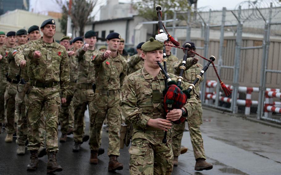 Coalition troops march behind a bagpiper before a ceremony at the military headquarters in Kabul, Afghanistan on Wednesday, Nov. 11, 2015. Servicemembers and civilians from a variety of allied countries gathered to pay tribute to troops who have died in wars, past and present.