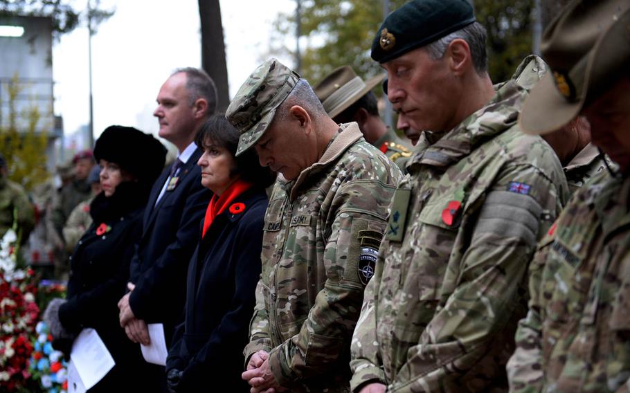 Gen. John Campbell, center, bows his head while standing between civilian ambassadors and allied military commanders at a ceremony to honor fallen troops. Campbell, the top American and coalition commander in Afghanistan, was among the participants who laid wreaths and said prayers in remembrance.