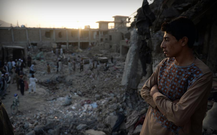A boy looks across the devastation caused by a massive truck bomb in Kabul, Afghanistan, on Aug. 7, 2015. The bomb primarily struck civilians, who are now struggling to rebuild their lives after losing everything.