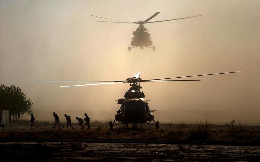 Men run from an Afghan air force Mi-17 helicopter as it lands at a military base outside of Kunduz city, Oct. 7, 2015. Aircraft played a major role in shuttling reinforcements and supplies after Taliban forces seized the city and blocked roads.
