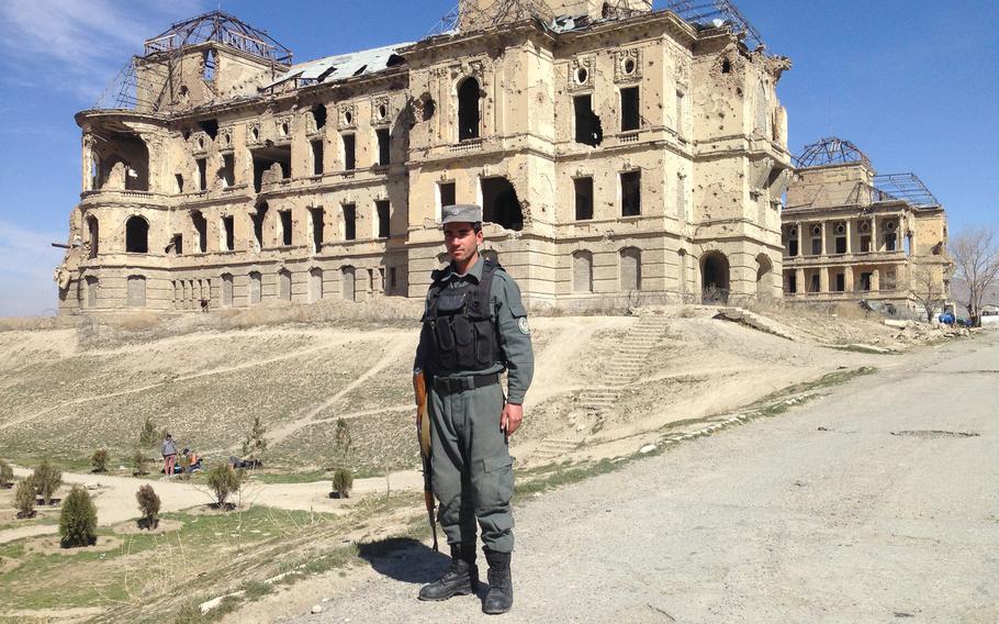 A police officer guards the main driveway to Kabul's bombed-out Darul Aman Palace on Sunday, Feb. 28, 2016. Reconstruction work on the complex, destroyed in fighting between rival warlords in the 1990s, has recently started.